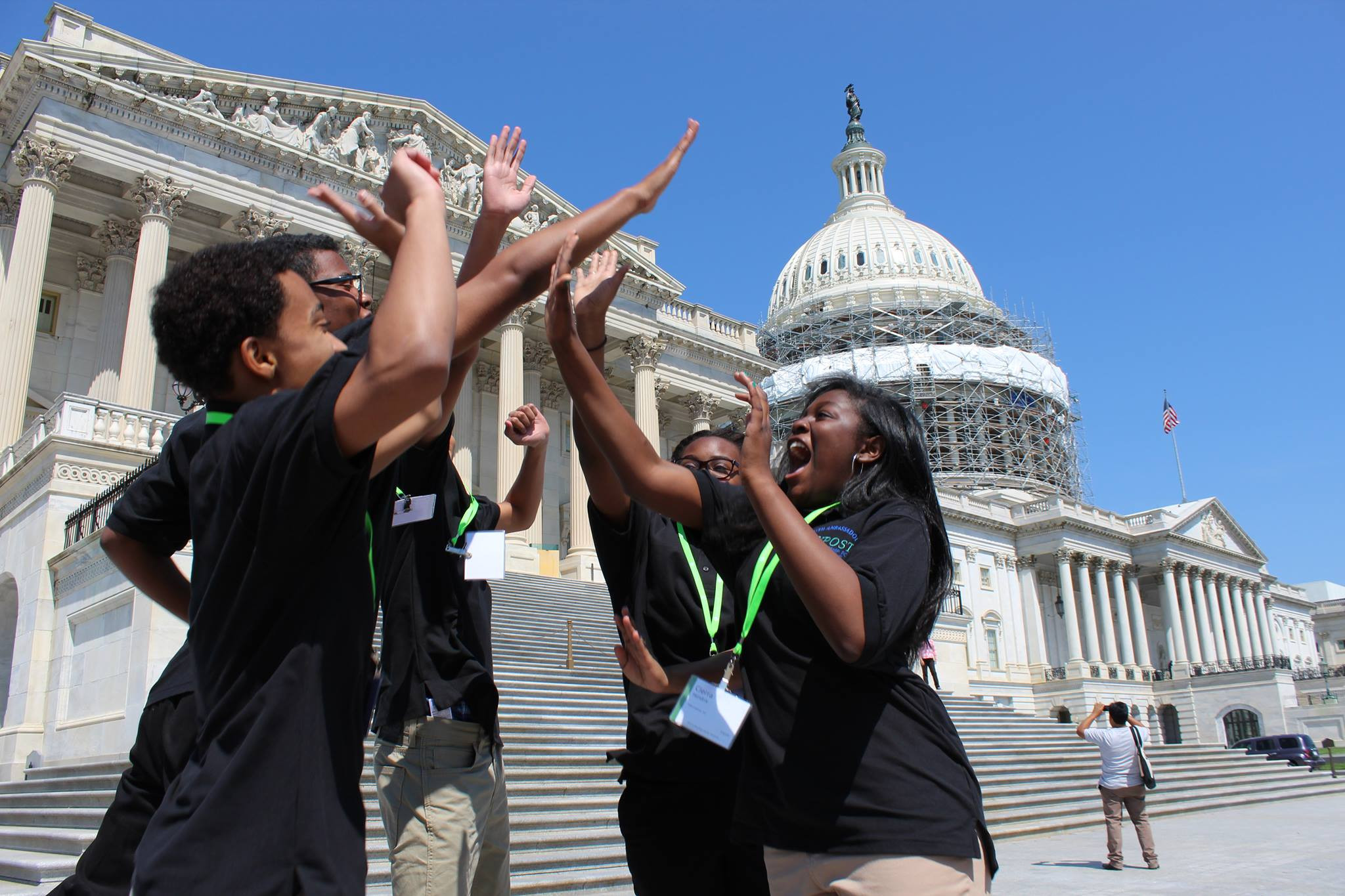 Five kids high-fiving in front of the US Capitol Building.