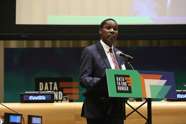 A man in a suit speaks at the Data to End Hunger event.